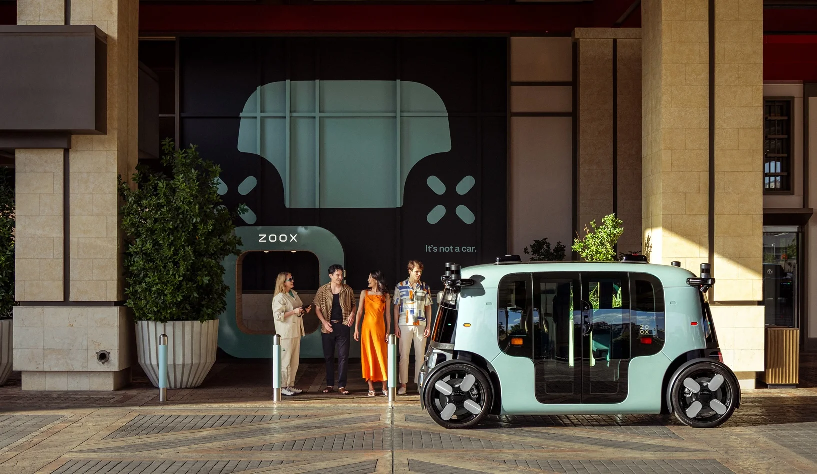 Four-people-waiting-for-a-Zoox-robotaxi-at-Resorts-World-Las-Vegas.webp